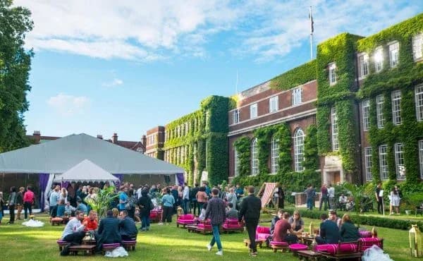 A summer party on an ivy-clad college lawn with a marquee